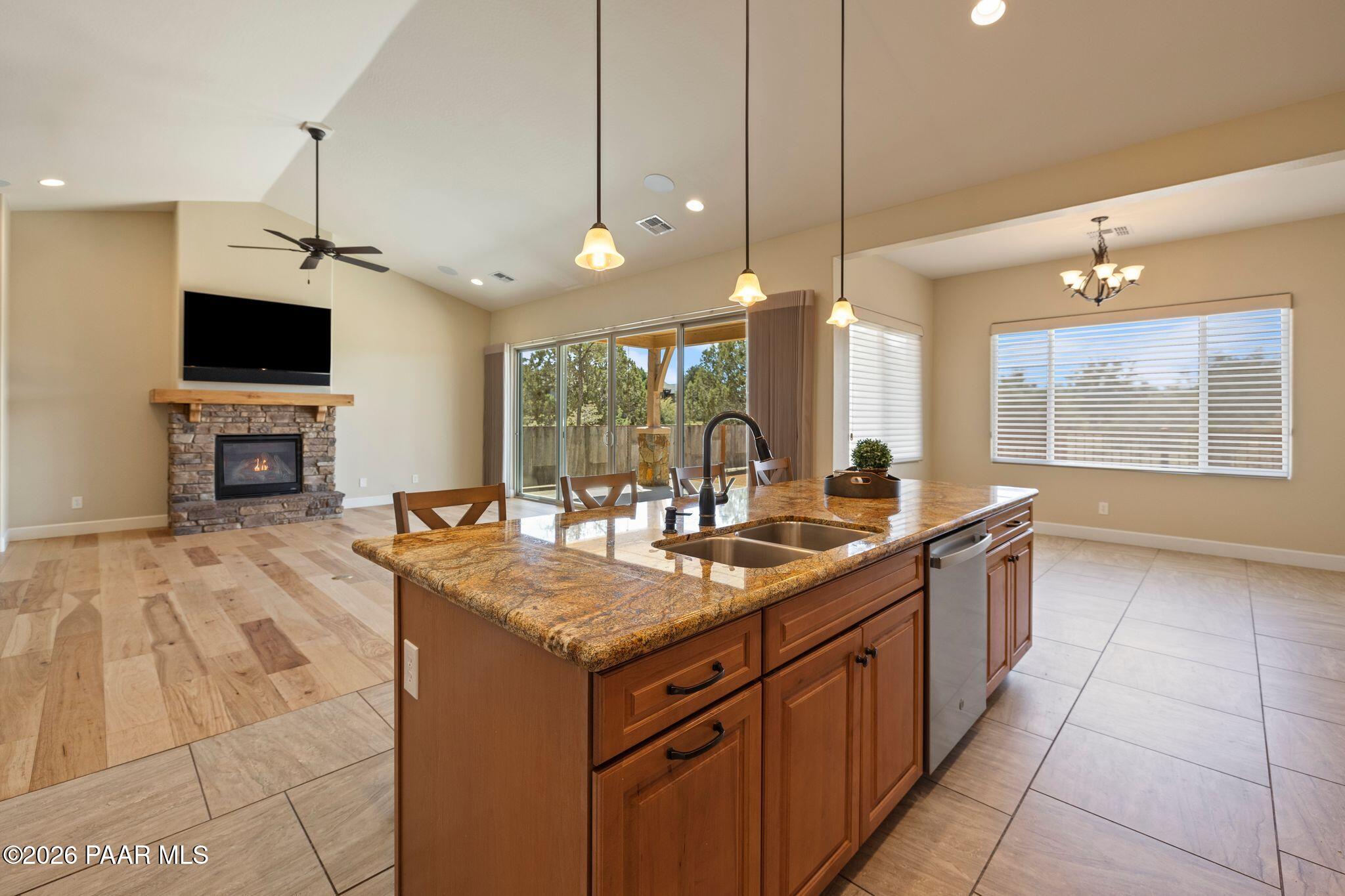 4850 West Three Forks Road Prescott, AZ 86305 - Photo 16 of 69 a kitchen with kitchen island granite countertop a sink appliances and a fireplace