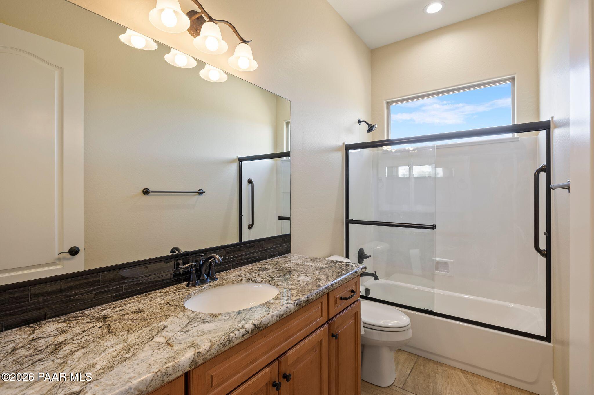 4850 West Three Forks Road Prescott, AZ 86305 - Photo 33 of 69 a bathroom with a granite countertop sink toilet and shower