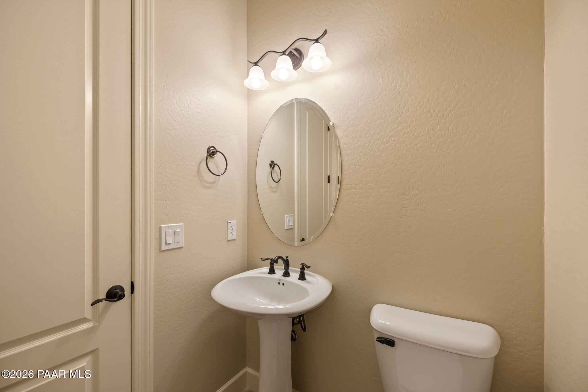 4850 West Three Forks Road Prescott, AZ 86305 - Photo 36 of 69 a bathroom with a toilet sink and mirror