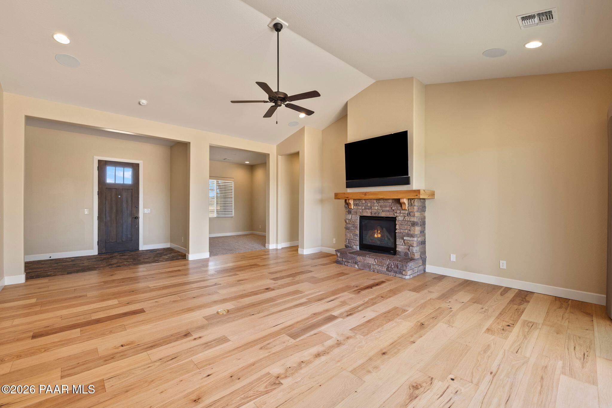 4850 West Three Forks Road Prescott, AZ 86305 - Photo 10 of 69 a view of a livingroom with a fireplace a chandelier and wooden floor