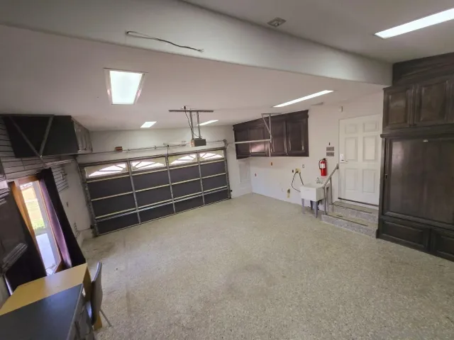 a view of an empty room with cabinet and mirrors