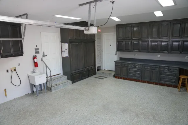 a large kitchen with stainless steel appliances kitchen island granite countertop a refrigerator and cabinets