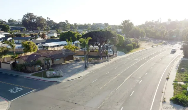 a front view of a house with a yard and potted plants