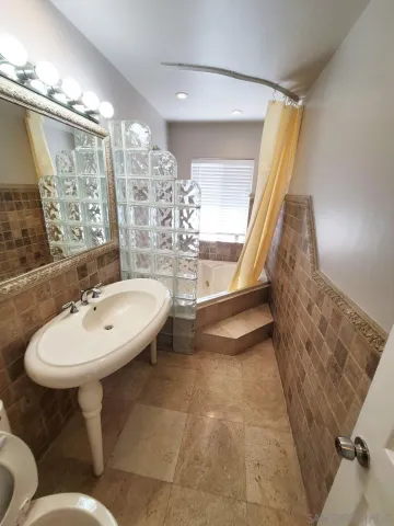 a bathroom with a sink a toilet a mirror and shower