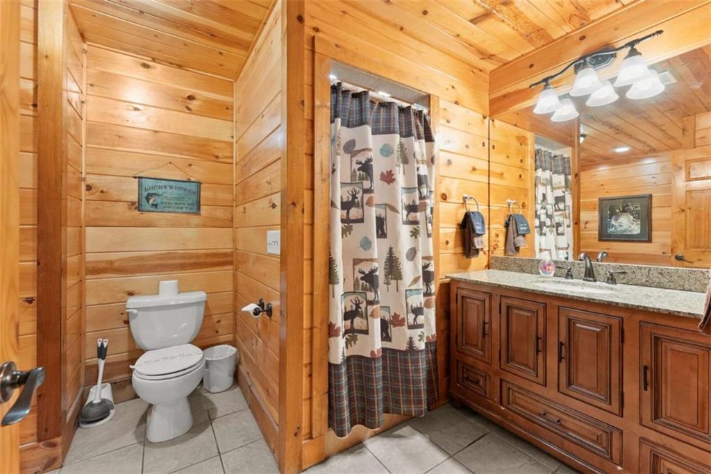 53 Elm Ridge Drive Cleveland, GA 30528 - Photo 22 of 60 a bathroom with a granite countertop toilet a sink a mirror and a shower