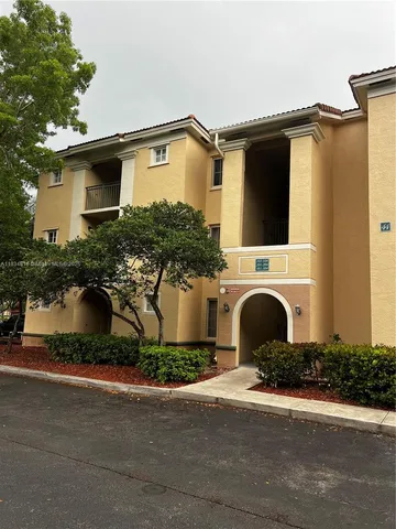 a front view of a house with yard and parking