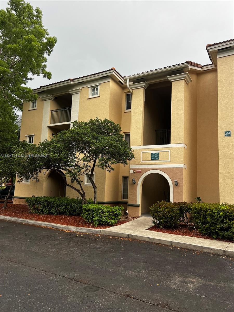 a front view of a house with yard and parking