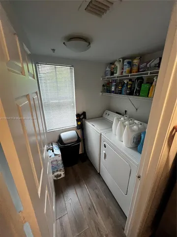 a utility room with dryer washer and a view of living room