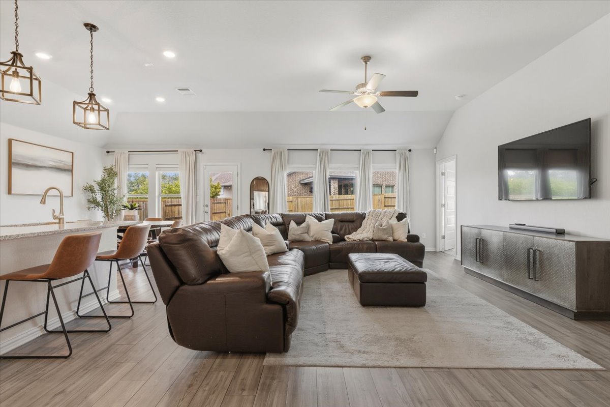 366 Cold Riv Run Kyle, TX 78640 - Photo 11 of 31 Open-concept living space with wood-finish flooring, recessed lighting, and vaulted ceilings