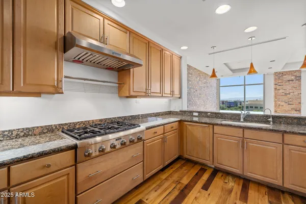 a kitchen with granite countertop cabinets stainless steel appliances and a counter space