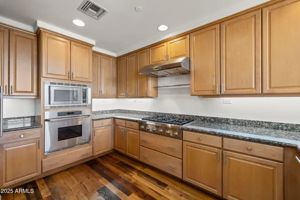 a kitchen with stainless steel appliances granite countertop a refrigerator and a sink