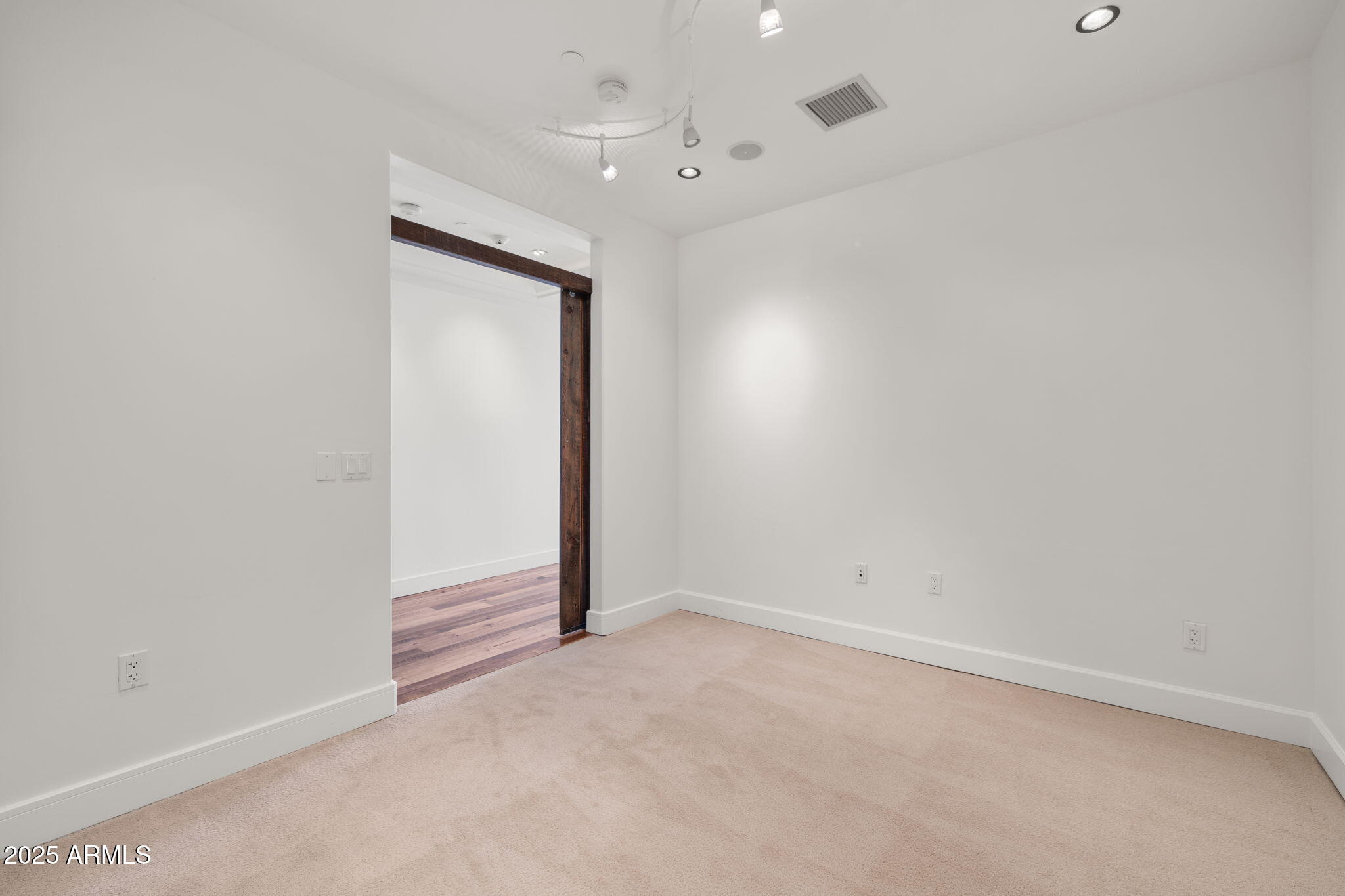 2211 East Camelback Road, Unit 607 Phoenix, AZ 85016 - Photo 15 of 41 an empty room with a ceiling fan and carpet