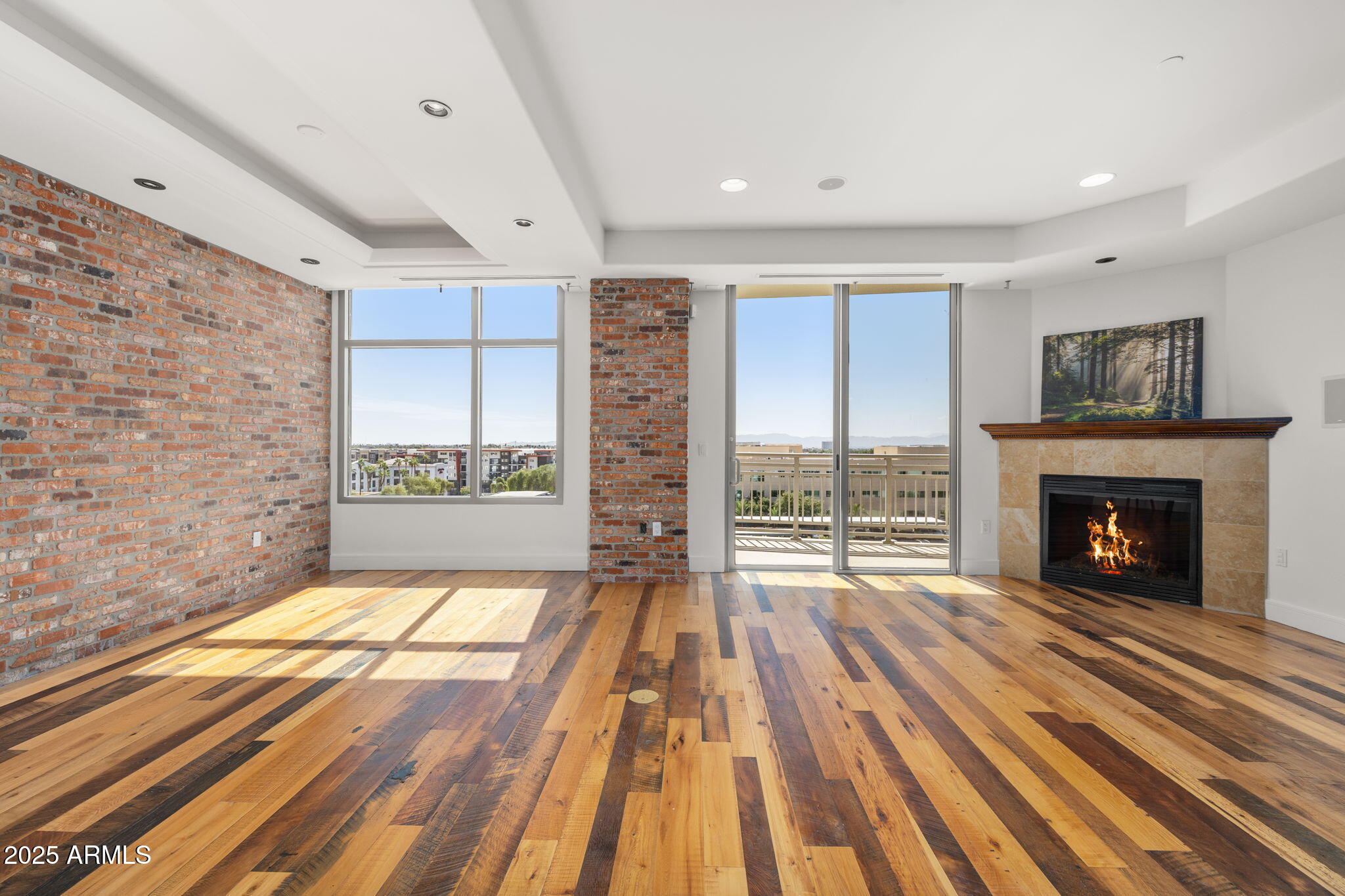 2211 East Camelback Road, Unit 607 Phoenix, AZ 85016 - Photo 5 of 41 a view of empty room with wooden floor and fireplace
