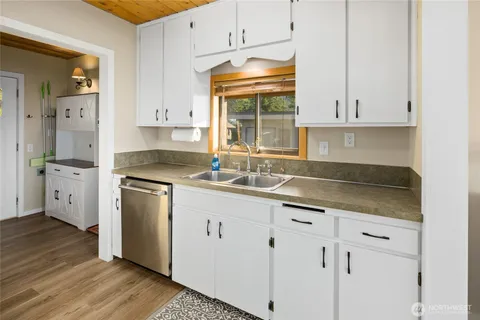 a kitchen with granite countertop white cabinets and white appliances