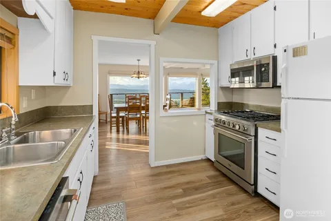 a kitchen with granite countertop a stove a sink and a microwave