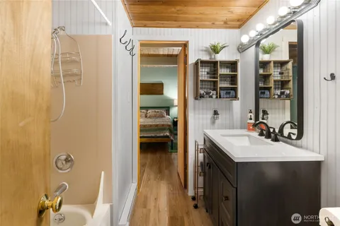 a bathroom with a sink mirror and shower