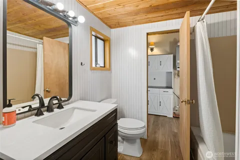 a bathroom with a sink a toilet a large mirror and shower