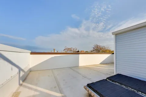a spacious bedroom with a bed and wooden floor