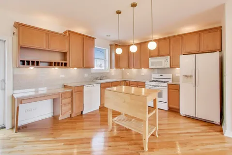 a kitchen with kitchen island white cabinets and stainless steel appliances