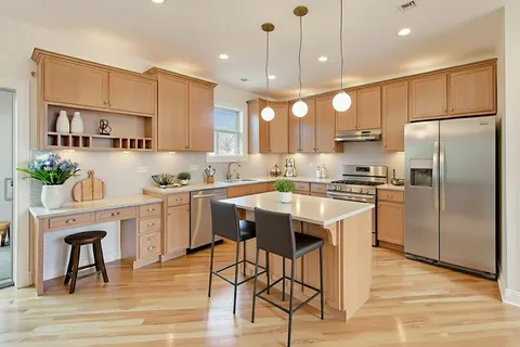 a kitchen with kitchen island white cabinets and stainless steel appliances