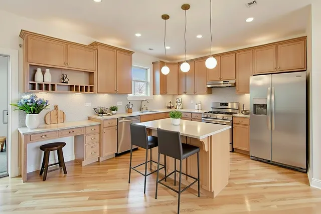 a kitchen with kitchen island white cabinets and stainless steel appliances