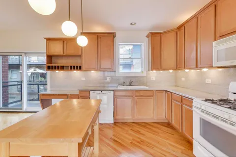 a kitchen with granite countertop a sink a stove and cabinets