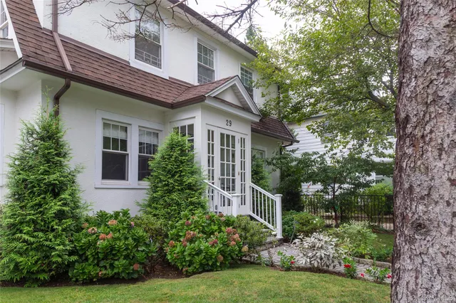 a front view of a house with a yard and trees