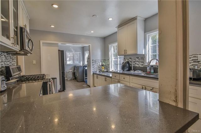 a kitchen with stainless steel appliances granite countertop a sink stove and cabinets