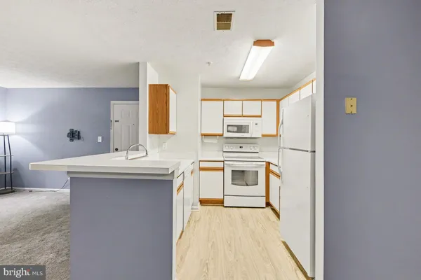 a kitchen with a refrigerator sink stove and cabinets