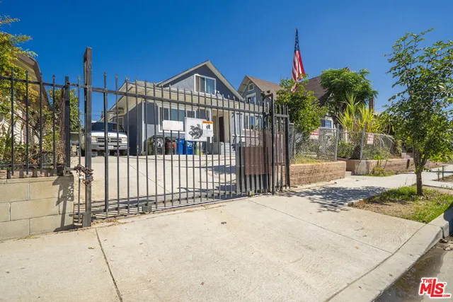 a view of a house with a small yard and wooden fence