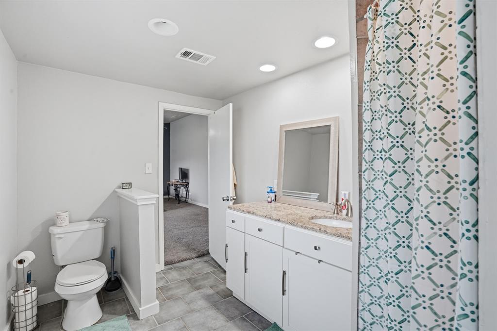 7701 John T White Road Fort Worth, TX 76120 - Photo 15 of 23 a bathroom with a granite countertop sink toilet and mirror