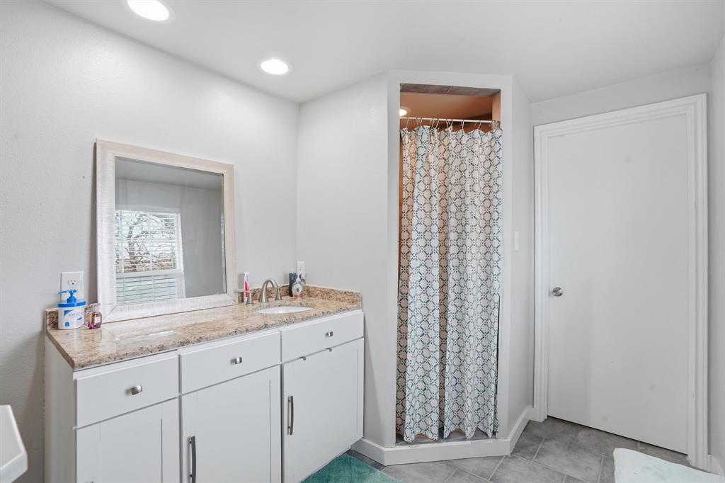 7701 John T White Road Fort Worth, TX 76120 - Photo 16 of 23 a bathroom with a granite countertop sink vanity and mirror