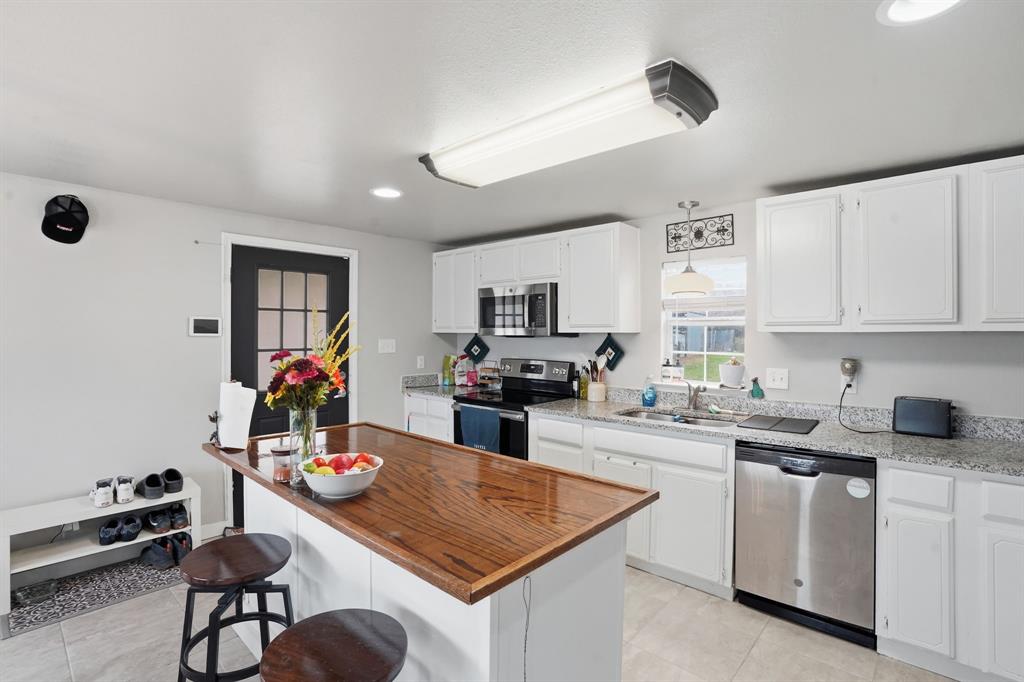 7701 John T White Road Fort Worth, TX 76120 - Photo 7 of 23 a kitchen with sink a microwave and cabinets