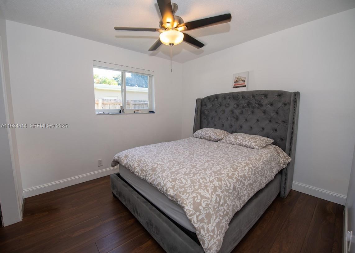 5012 Taft Street Hollywood, FL 33021 - Photo 15 of 36 a bedroom with a bed and a chandelier