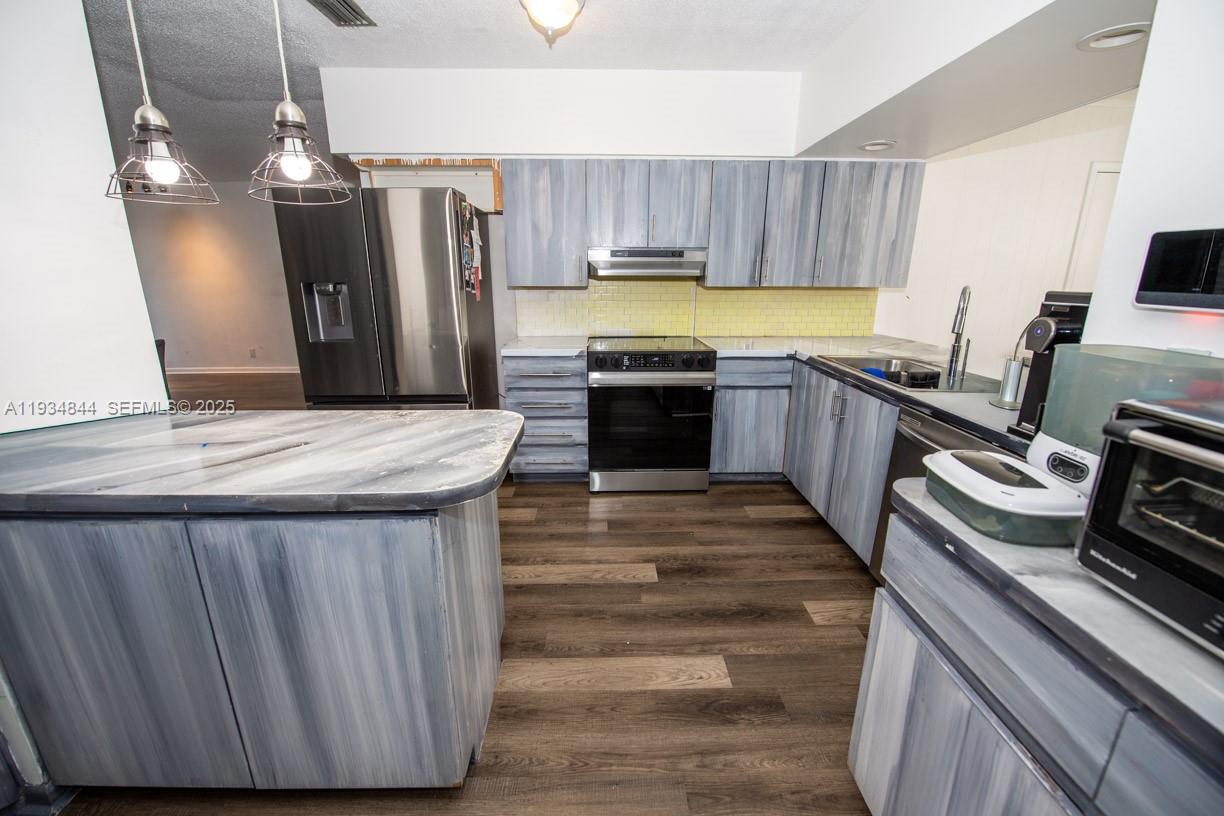 5012 Taft Street Hollywood, FL 33021 - Photo 8 of 36 a kitchen with kitchen island a counter space a sink appliances and cabinets
