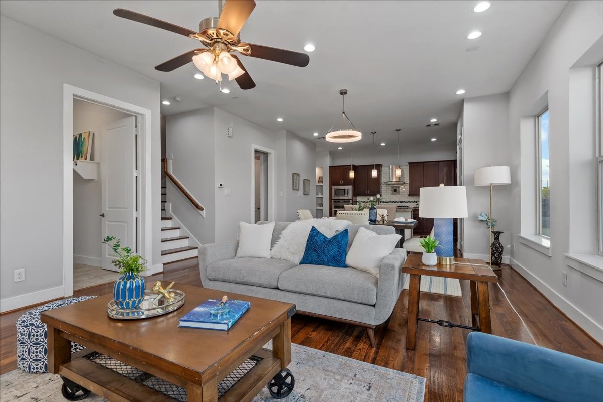 1005 Bingham Street, Unit 5 Houston, TX 77007 - Photo 11 of 50 This spacious, open-concept living area features elegant hardwood floors, a comfortable seating arrangement, and modern lighting. The layout flows seamlessly into a contemporary kitchen and dining area, creating an ideal setting for entertaining. Expansive windows fill the space with abundant natural light, enhancing its warm and inviting atmosphere.
