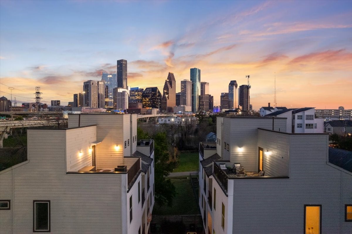 1005 Bingham Street, Unit 5 Houston, TX 77007 - Photo 20 of 50 Modern home with rooftop terrace offers stunning views of the city skyline at sunset, providing a picturesque and urban living experience.
