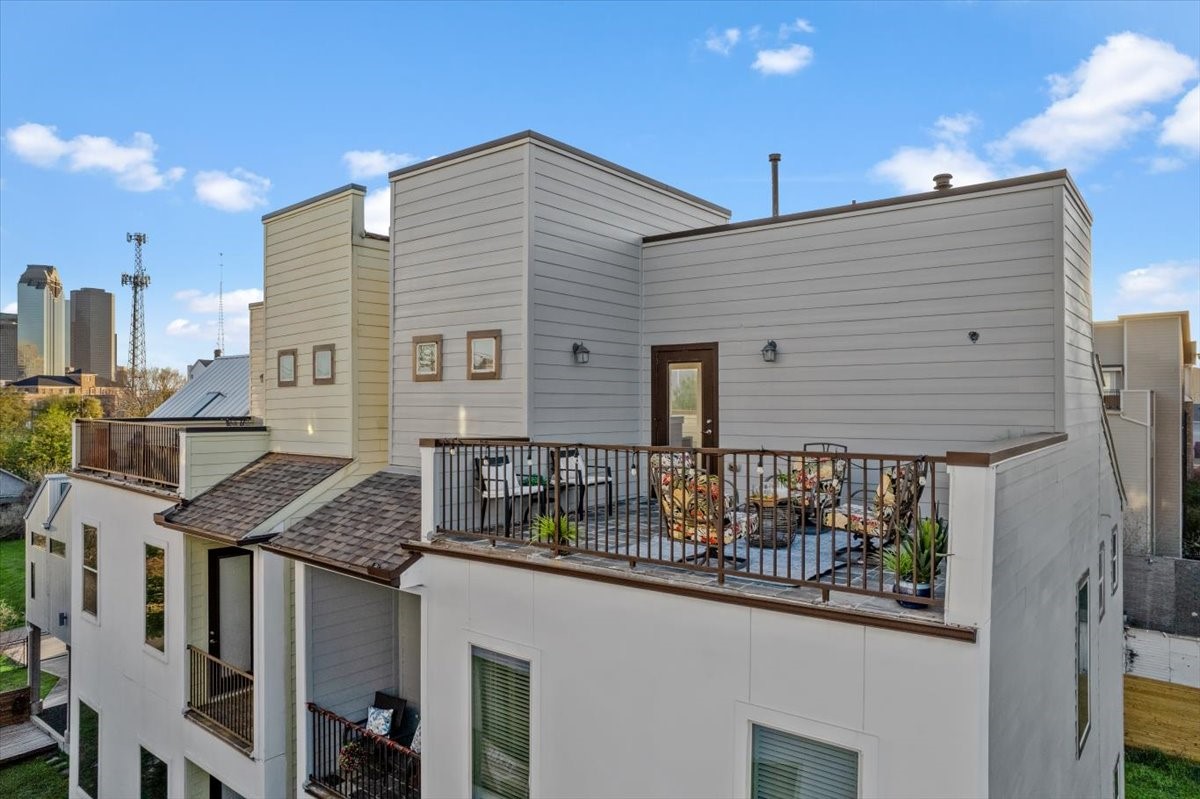 1005 Bingham Street, Unit 5 Houston, TX 77007 - Photo 26 of 50 This modern home features a spacious rooftop terrace with seating, offering cityscape views. The exterior is sleek with clean lines and multiple levels, perfect for urban living.