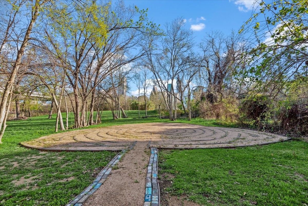 1005 Bingham Street, Unit 5 Houston, TX 77007 - Photo 30 of 50 This photo showcases a serene outdoor area around the corner featuring a circular stone path amidst a lush, wooded setting. Ideal for relaxation or meditation, it offers a peaceful retreat within nature.