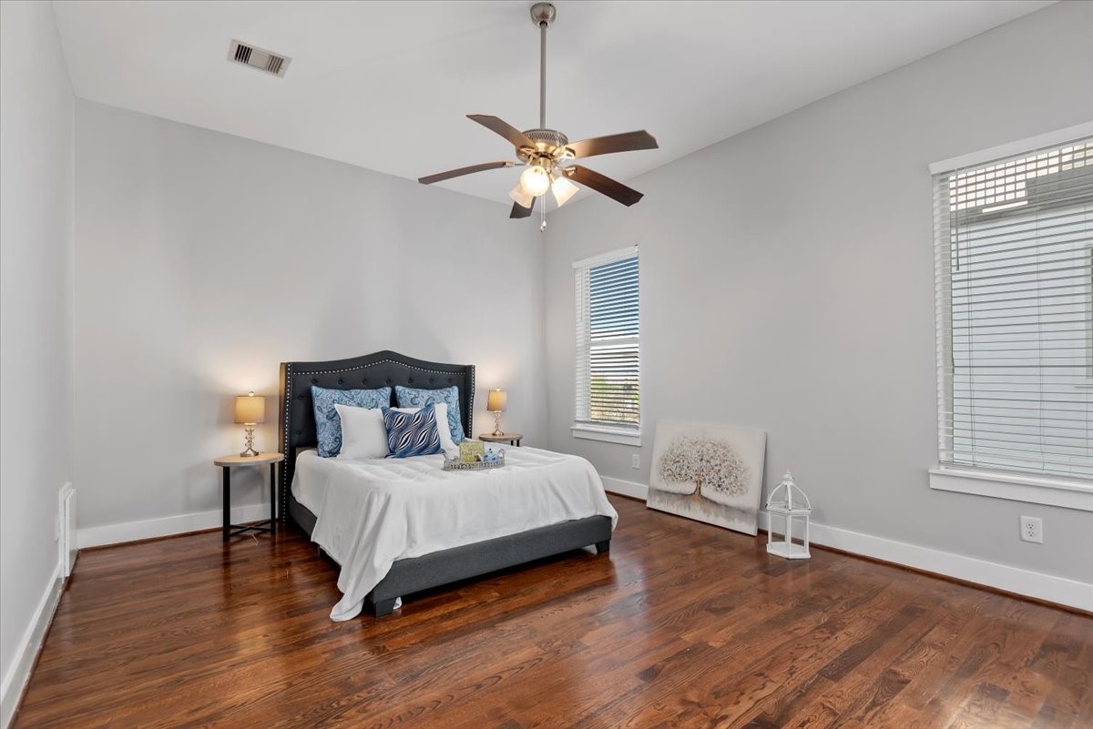 1005 Bingham Street, Unit 5 Houston, TX 77007 - Photo 36 of 50 This primary bedroom features hardwood floors, a ceiling fan, and ample natural light. It has an in suite full bathroom and a door that leads to a cozy balcony