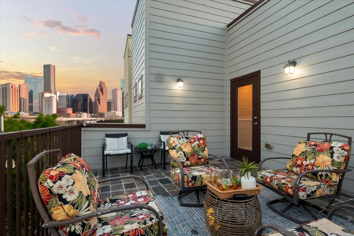 1005 Bingham Street, Unit 5 Houston, TX 77007 - Photo 6 of 50 This rooftop patio offers a cozy seating area complemented by ambient wall lighting. Enjoy stunning city skyline views, perfect for relaxing or entertaining.