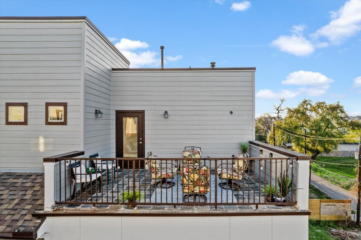 1005 Bingham Street, Unit 5 Houston, TX 77007 - Photo 7 of 50 This photo features a modern rooftop patio with stylish furniture and potted plants, perfect for outdoor relaxation. The space is enclosed by a sleek railing, providing a cozy and inviting atmosphere with views of the surrounding area.