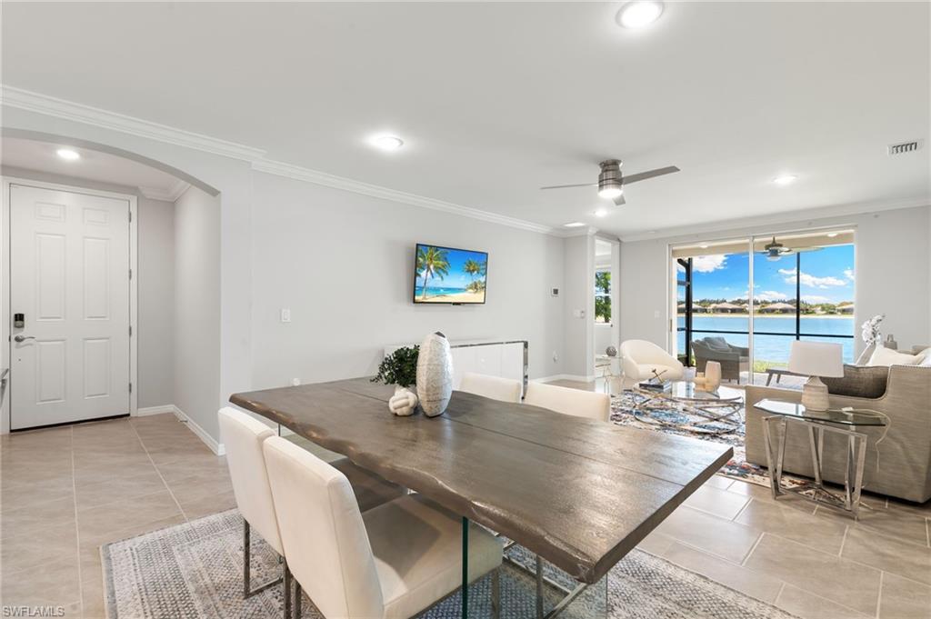 14618 Edgewater Circle Naples, FL 34114 - Photo 11 of 47 a room with stainless steel appliances a dining table and chairs with wooden floor