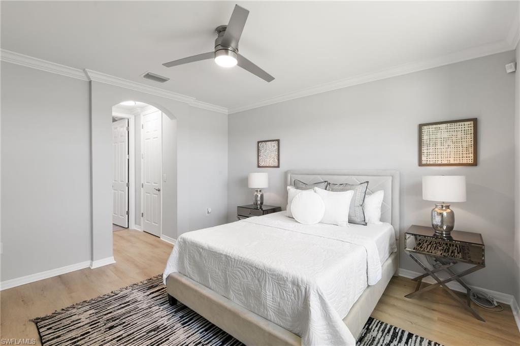 14618 Edgewater Circle Naples, FL 34114 - Photo 19 of 47 a bedroom with a bed and wooden floor