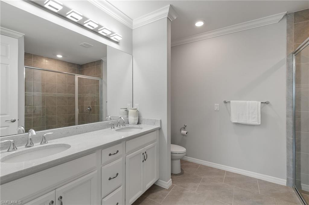 14618 Edgewater Circle Naples, FL 34114 - Photo 20 of 47 a bathroom with a double vanity sink and a mirror