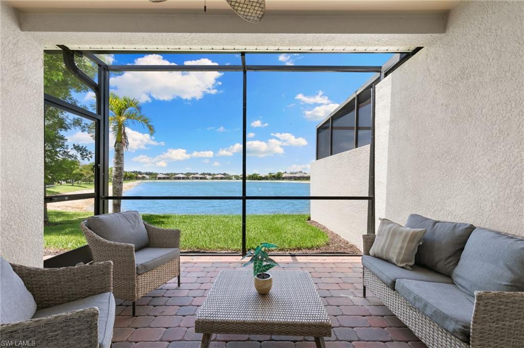 14618 Edgewater Circle Naples, FL 34114 - Photo 26 of 47 a living room with furniture and a floor to ceiling window