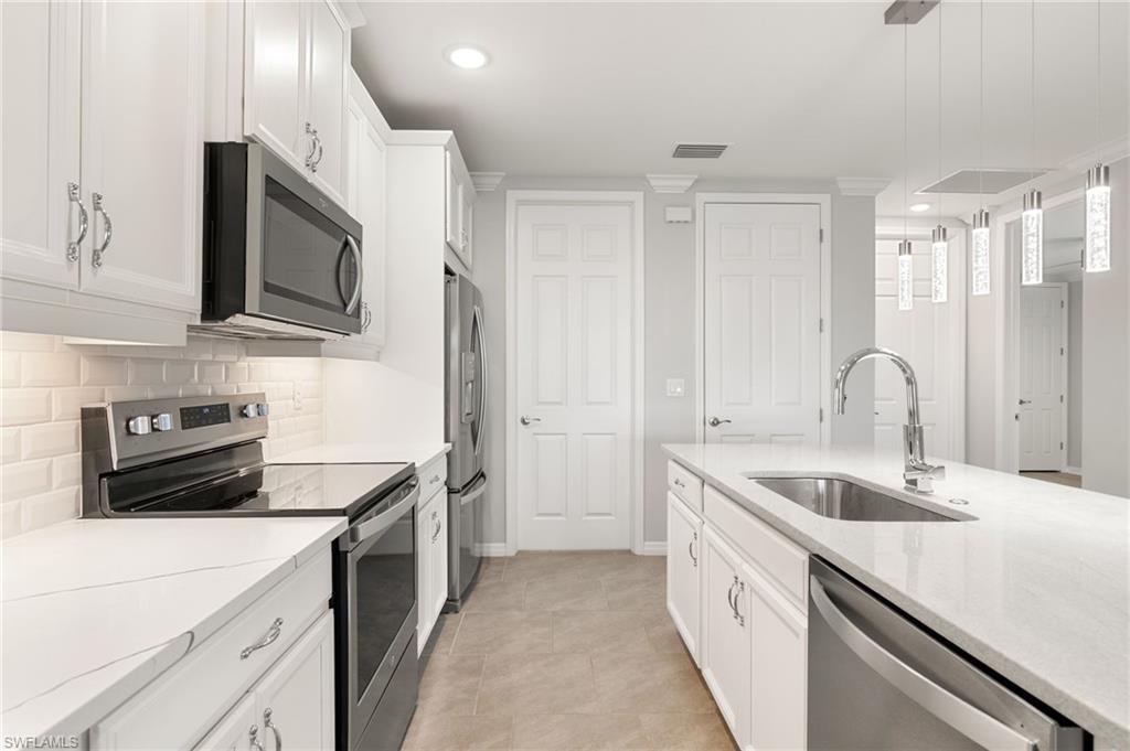 14618 Edgewater Circle Naples, FL 34114 - Photo 8 of 47 a kitchen with a sink stove and microwave