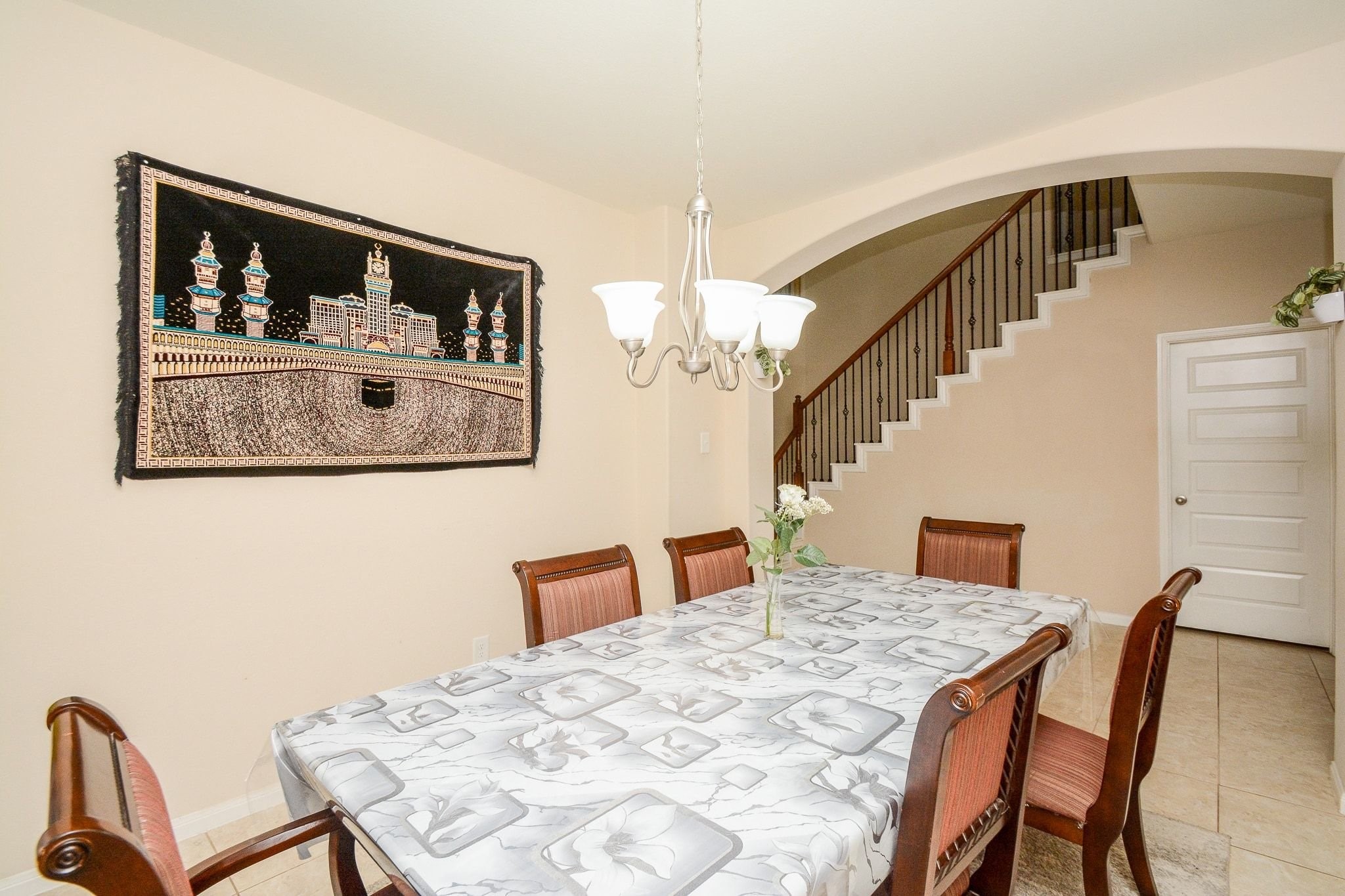 7046 Sliding Rock Circle Spring, TX 77379 - Photo 6 of 41 This elegant dining room offers a warm ambiance, featuring a stylish chandelier and a spacious table perfect for gatherings. An archway leads to a charming staircase, adding character to the space.