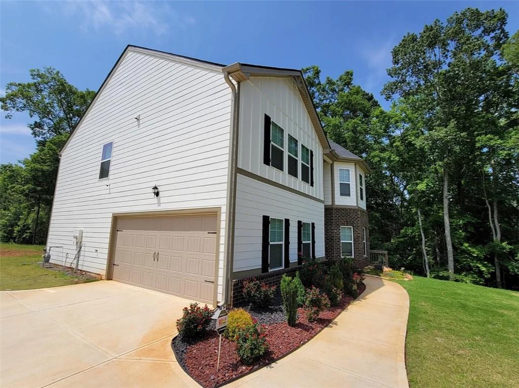 a front view of a house with a yard and potted plants