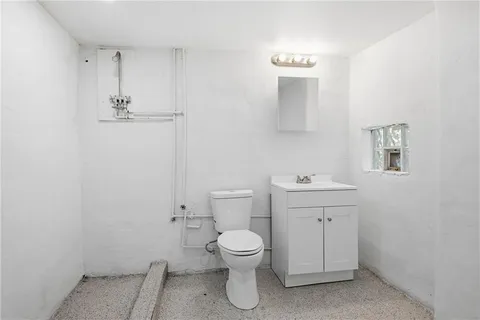 a bathroom with a toilet a sink and mirror